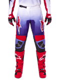 Alpinestars 2025 Fluid Wurx Pants, spodnie motocrossowe, fioletowe i jaskrawoczerwone, noszone z dopasowanymi czerwonymi butami i rękawicami, białe logo na udach i czarne wzmocnienia na kolanach, profesjonalna odzież do jazdy terenowej