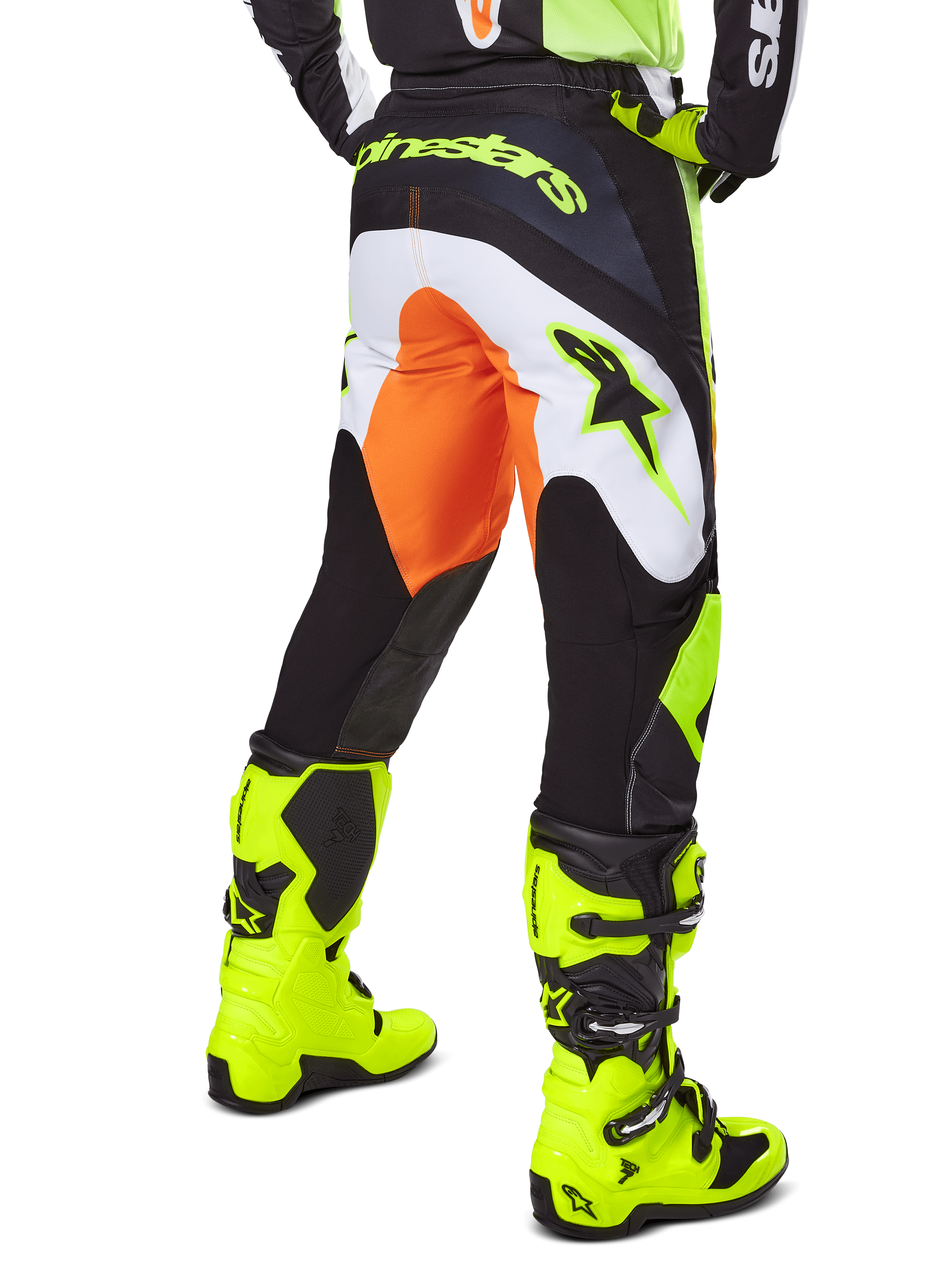 Alpinestars 2025 Fluid Wurx Pants, spodnie motocrossowe, żółto-czarne z pomarańczowymi i białymi akcentami, widok z tyłu, prezentowane z pasującymi jaskrawożółtymi butami, wytrzymała konstrukcja z wyraźnym brandingiem do jazdy na motocyklu terenowym