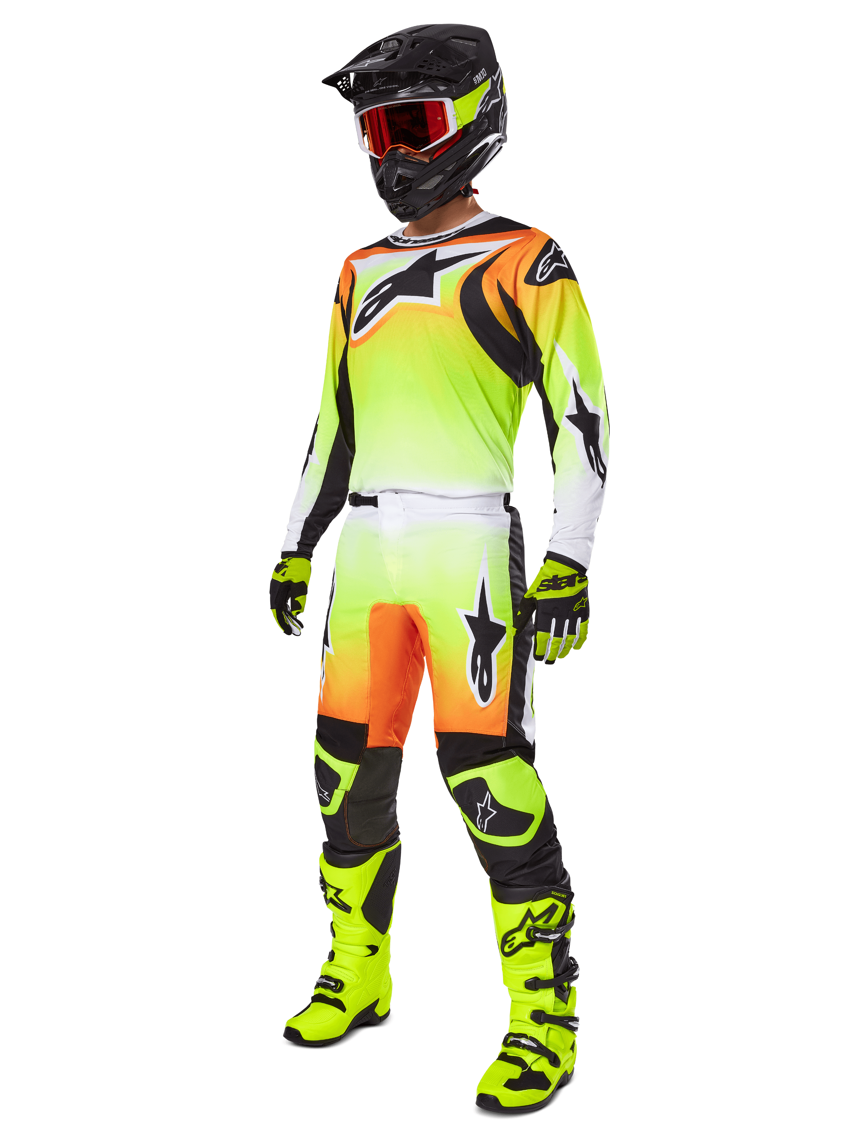 Zawodnik motocrossowy w spodniach Alpinestars 2025 Fluid Wurx w kolorze żółto-czarnym, wyrazisty gradient od żółtego do białego z pomarańczowymi i czarnymi akcentami, kompletny zestaw wyścigowy z pasującą koszulką, czarnym kaskiem i neonowo-żółtymi butami