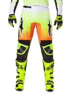 Alpinestars 2025 Fluid Wurx Pants, spodnie motocrossowe, neonowy żółty i pomarańczowy, czarno-białe logo gwiazdy, smukły wyścigowy design z czarnymi sekcjami na kolanach, zestawione z pasującymi butami i rękawicami w kolorze neonowym żółtym