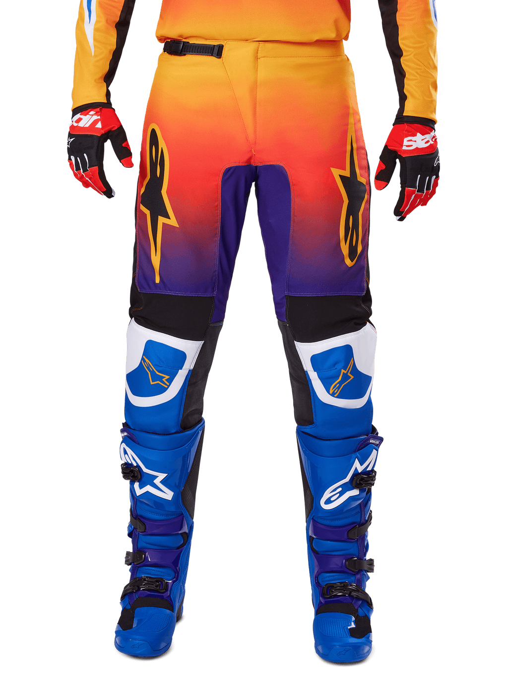 Alpinestars 2025 Fluid Wurx Pants, spodnie motocrossowe, wielokolorowe z gradientem od pomarańczowego do fioletowego i niebieskimi panelami, zestawione z pasującymi niebiesko-fioletowymi butami i czerwono-czarnymi rękawicami, widok z przodu z logo gwiazdy