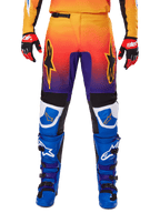 Alpinestars 2025 Fluid Wurx Pants, spodnie motocrossowe, wielokolorowe z gradientem od pomarańczowego do fioletowego i niebieskimi panelami, zestawione z pasującymi niebiesko-fioletowymi butami i czerwono-czarnymi rękawicami, widok z przodu z logo gwiazdy