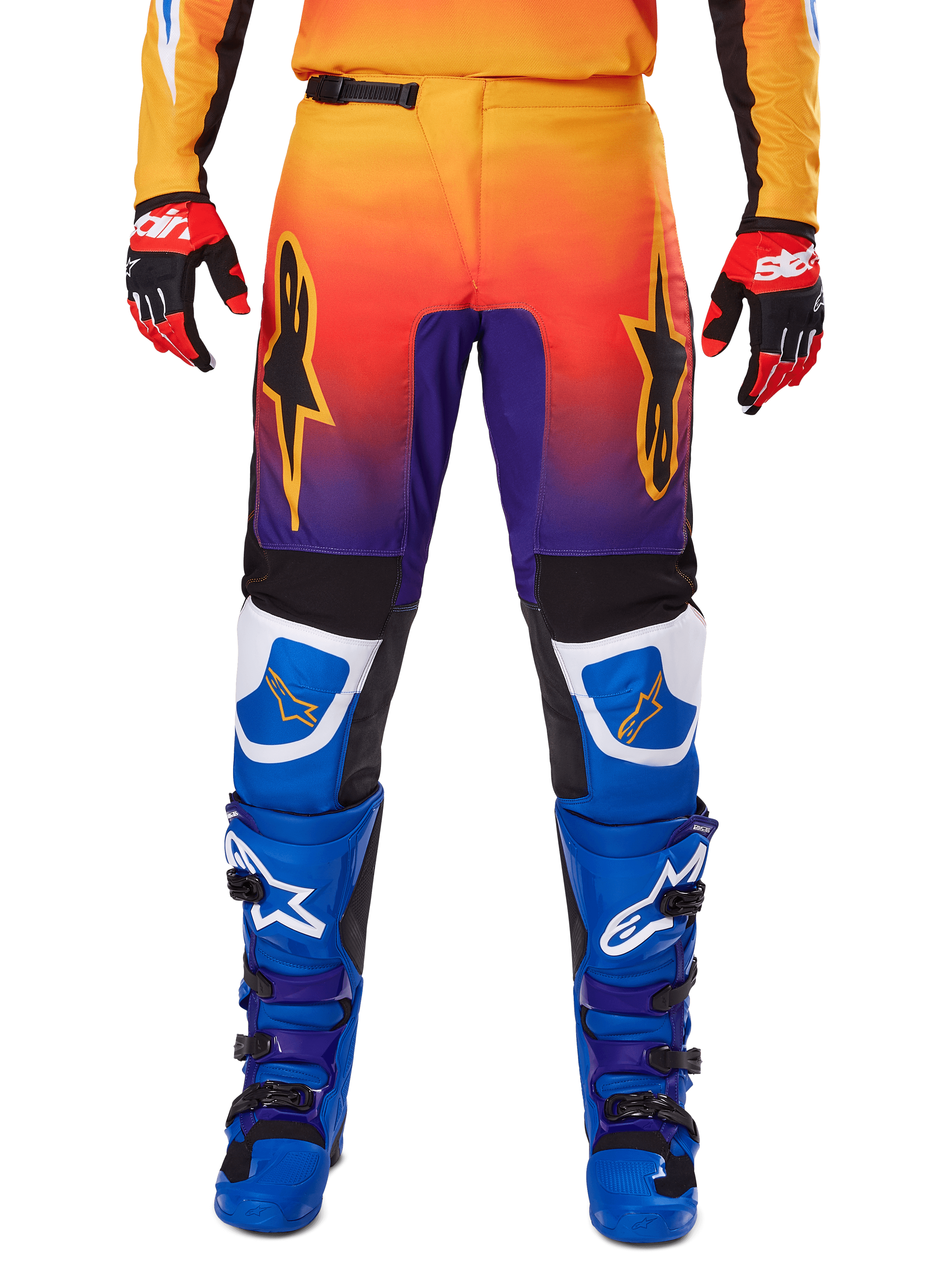 Alpinestars 2025 Fluid Wurx Pants, spodnie motocrossowe, wielokolorowe z gradientem od pomarańczowego do fioletowego i niebieskimi panelami, zestawione z pasującymi niebiesko-fioletowymi butami i czerwono-czarnymi rękawicami, widok z przodu z logo gwiazdy