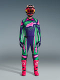 Alpinestars Techstar Nomur Gear Set 2026, strój motocrossowy, intensywne kolory zielony, fioletowy i różowy, duże logo gwiazdy na klatce piersiowej i udach, czarny kask z różowymi i żółtymi detalami, jaskraworóżowe buty, profesjonalny sportowy design