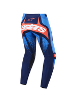 Alpinestars Techstar Nomur 2026, spodnie motocrossowe, ciemnogranatowe, pomarańczowe i jasnoniebieskie, widok z tyłu z wyraźnym białym logo astars na pomarańczowym panelu, wielopanelowa konstrukcja z jasnoniebieskimi akcentami, czarne wewnętrzne panele na kolanach, wytrzymała odzież do wyścigów terenowych