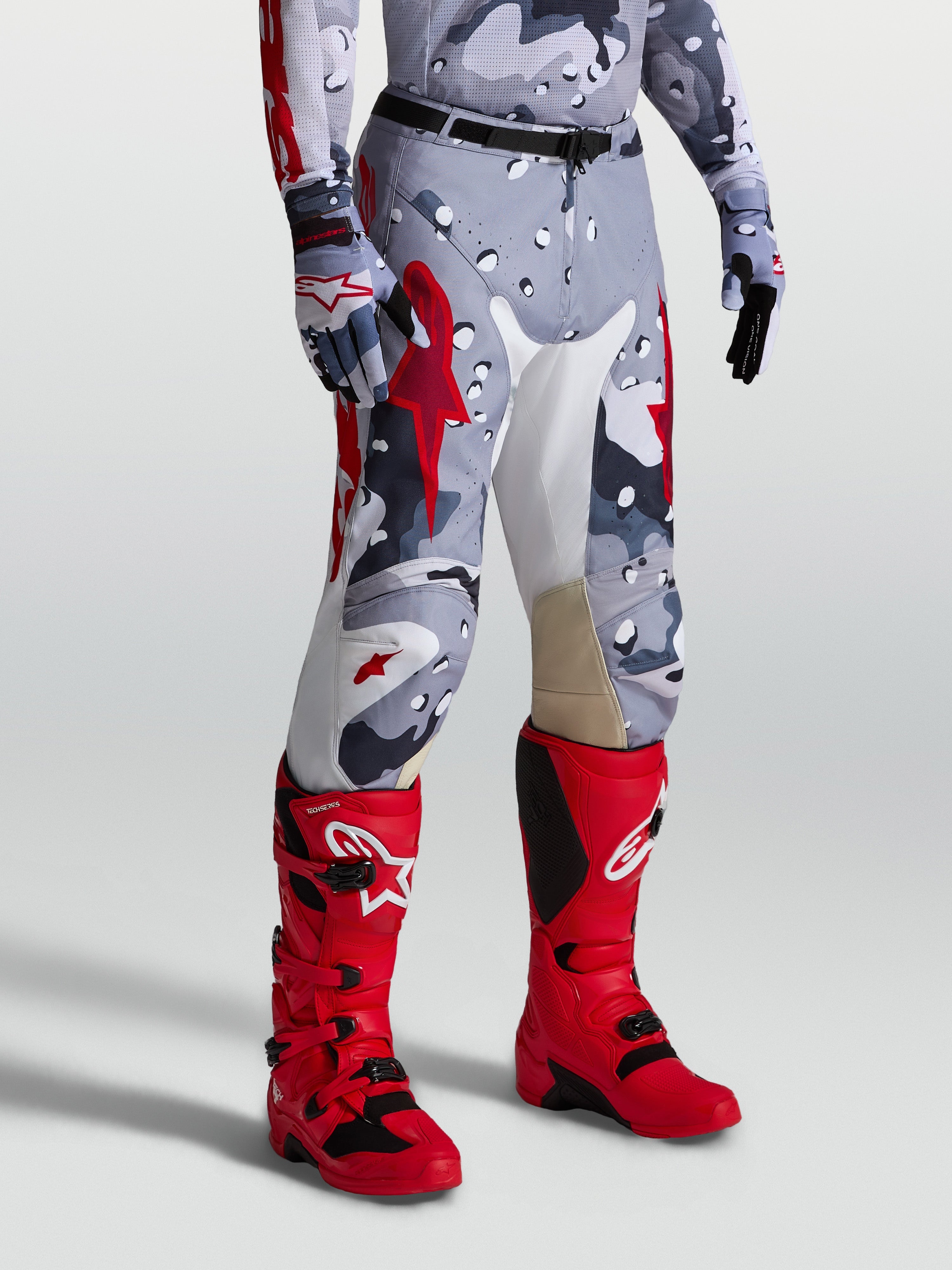 Spodnie Alpinestars Racer Air Lone, perforowany design off-road, męskie, szary kamuflaż i czerwone detale, na modelu.