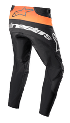 Alpinestars Techstar Sein Pants 2023, spodnie motocrossowe, czarne i jaskrawopomarańczowe, widok z tyłu pokazujący jaskrawopomarańczowy panel w pasie z czarnym logo, duże białe logo Alpinestars na siedzeniu, wzmocniona konstrukcja tekstylna do wyścigów off-road