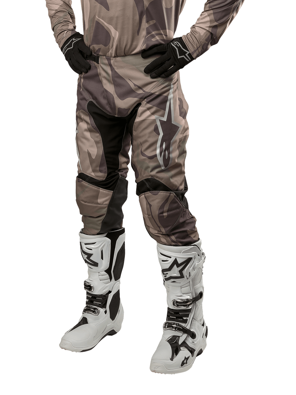 Alpinestars Racer Tactical Pants 2024, spodnie motocrossowe, wzór moro zielono-brązowy, noszone z pasującą koszulką moro, czarne rękawice i białe buty z logo gwiazdy, czarne panele elastyczne i ergonomiczny krój, zestaw odzieży terenowej na białym tle