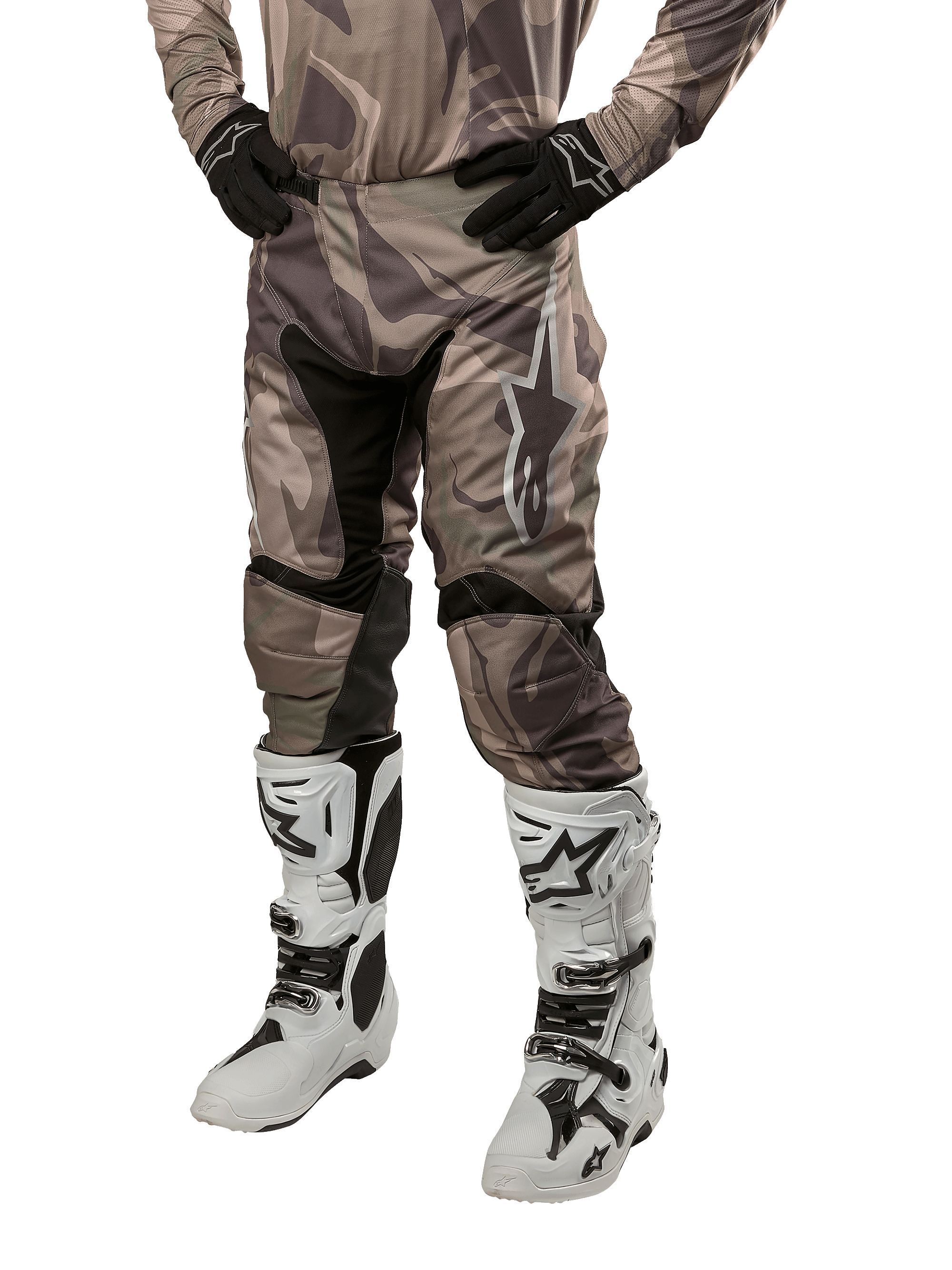 Alpinestars Racer Tactical Pants 2024, spodnie motocrossowe, wzór moro zielono-brązowy, noszone z pasującą koszulką moro, czarne rękawice i białe buty z logo gwiazdy, czarne panele elastyczne i ergonomiczny krój, zestaw odzieży terenowej na białym tle