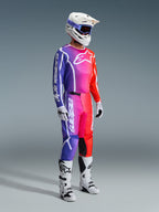 Alpinestars 2026 Fluid Apex Pants, spodnie motocrossowe, wielokolorowy gradient fioletu, różu i pomarańczu, zestawione z dopasowaną bluzą, białym kaskiem i białymi butami, z wyraźnym białym logo i ergonomicznym designem do wyścigów terenowych