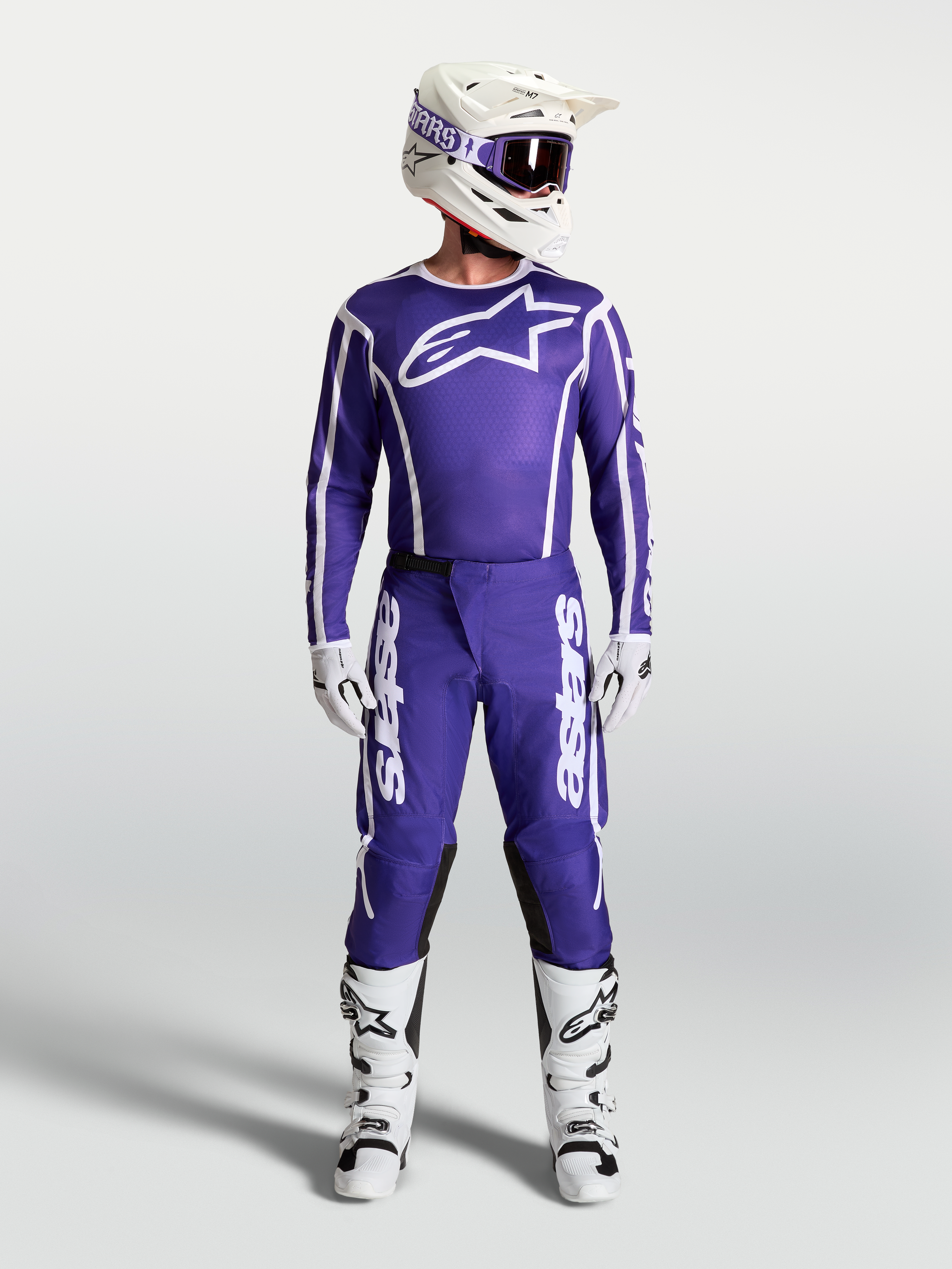 Alpinestars Spodnie Fluid Apex V2, męskie spodnie motocrossowe, ciemnoniebieskie i białe, z pasującą koszulką i butami.
