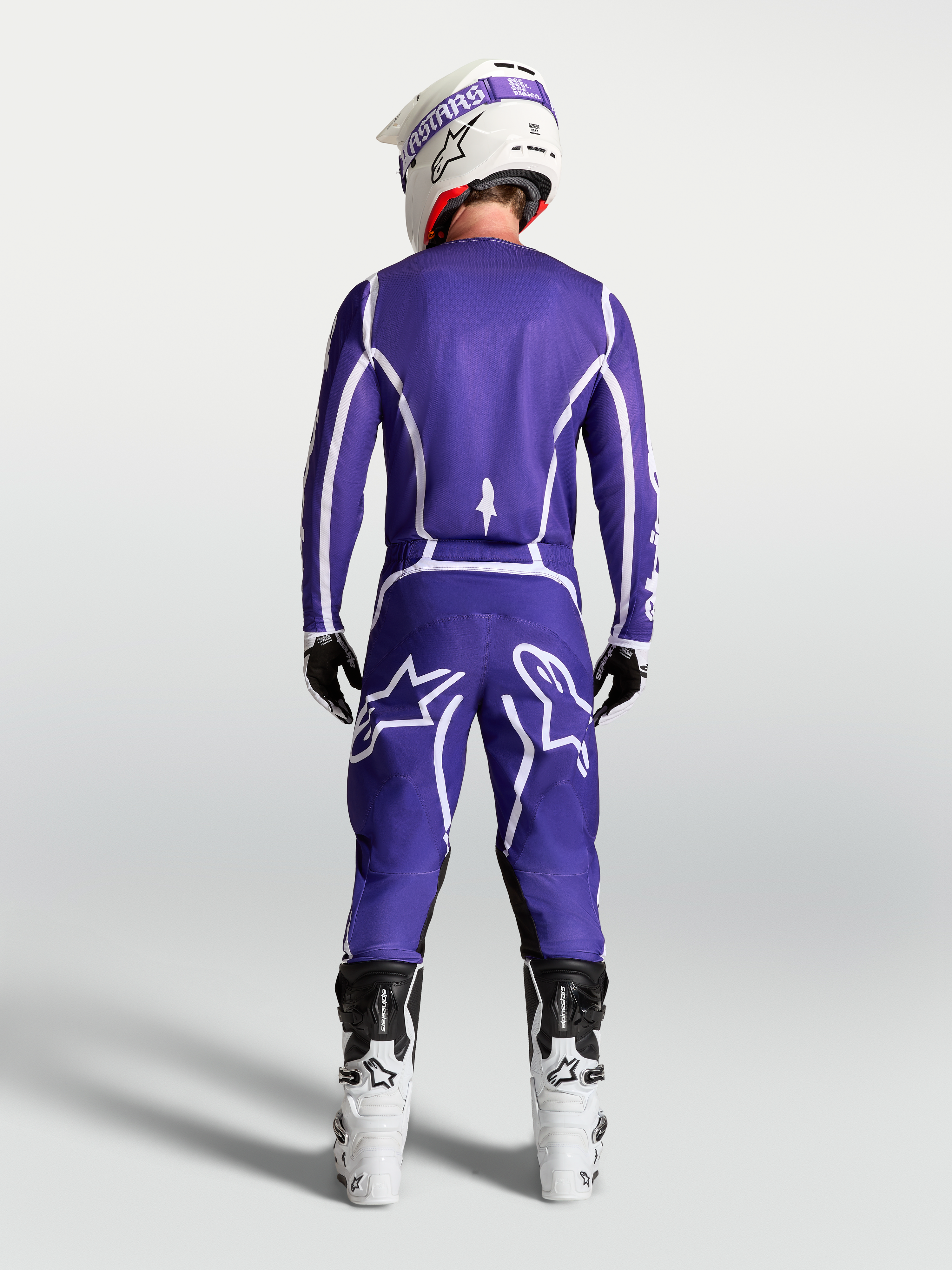 Alpinestars spodnie Fluid Apex V2, męskie spodnie motocrossowe, niebieskie i białe, widok z tyłu w białych butach.