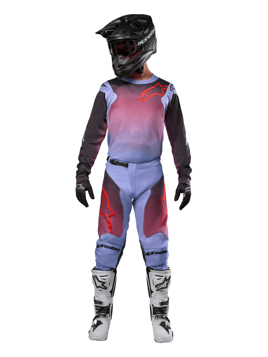 Motocyklista motocrossowy w kompletnym stroju wyścigowym, koszulka i spodnie Alpinestars Racer Hoen 2024, fioletowy Lavan i czarny z czerwonymi akcentami, czarny kask, biało-czarne buty, czarne rękawice, dopasowany zestaw do wyścigów terenowych