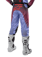 Alpinestars Racer Hoen Pants 2024, spodnie motocrossowe, fioletowo-czarne, widok od tyłu z dużym czerwonym logo gwiazdy na siedzeniu, białe buty motocrossowe, oddychające panele stretch na dolnej części nogawek