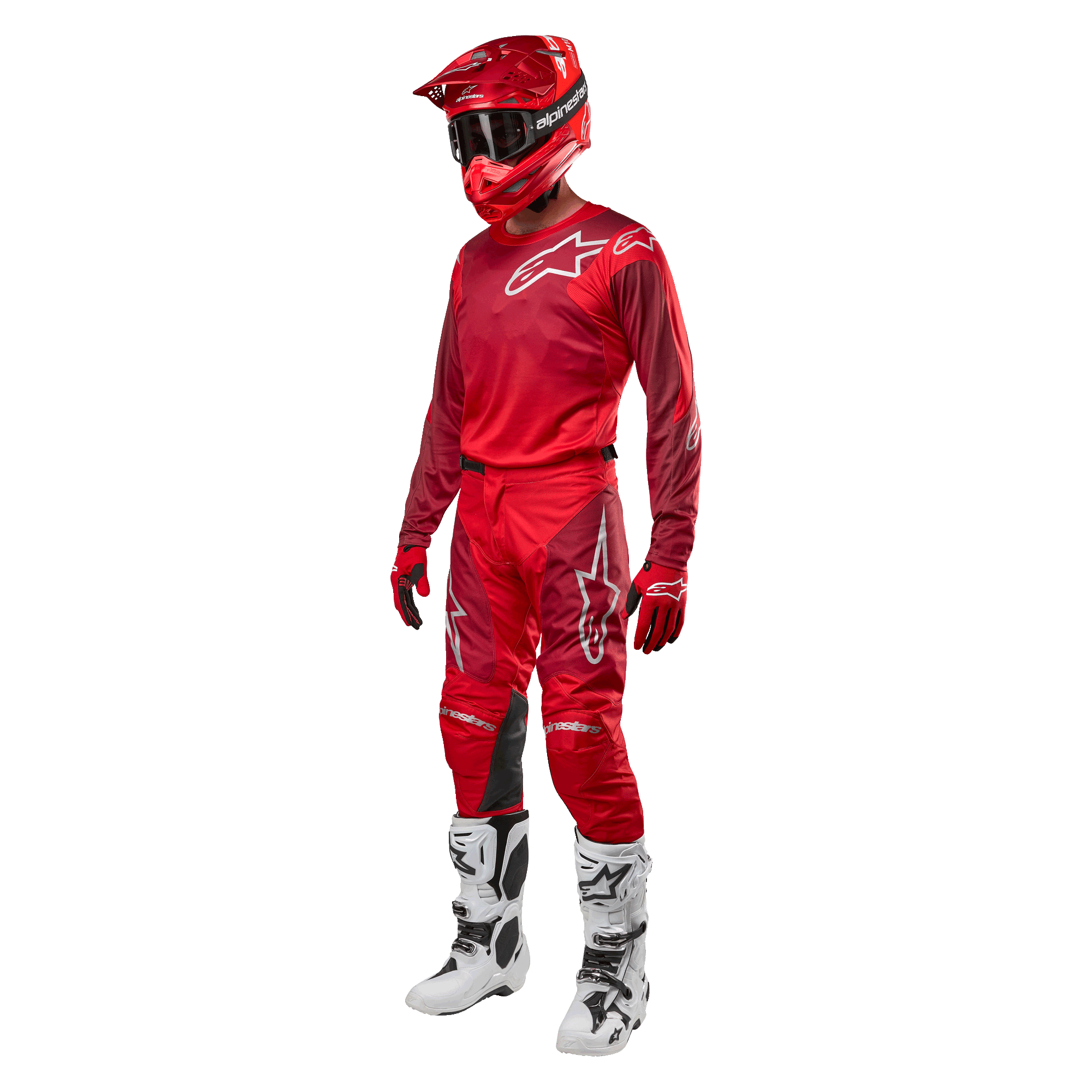 Motocyklista motocrossowy w pełnym stroju wyścigowym, spodnie i bluza Alpinestars Racer Hoen 2024 w kolorze Mars Red Burgundy, czerwony kask, czerwone rękawice oraz biało-czarne buty, dopasowany zestaw do wyścigów terenowych