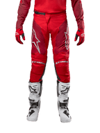 Alpinestars Racer Hoen Pants 2024, spodnie motocrossowe, kolor Mars Red Burgundy, widok z przodu ze srebrnym logo Alpinestars i brandingiem na kolanach, noszone z dopasowaną czerwoną bluzą, czerwono-czarnymi rękawicami i białymi butami terenowymi