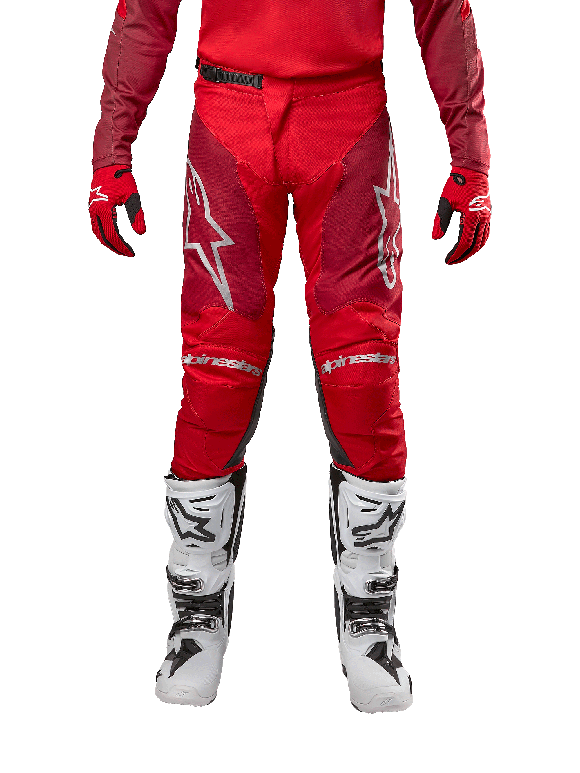 Alpinestars Racer Hoen Pants 2024, spodnie motocrossowe, kolor Mars Red Burgundy, widok z przodu ze srebrnym logo Alpinestars i brandingiem na kolanach, noszone z dopasowaną czerwoną bluzą, czerwono-czarnymi rękawicami i białymi butami terenowymi