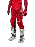 Alpinestars 2024 Racer Hoen Pants, spodnie motocrossowe, w kolorze Mars Red i bordowym, zestawione z pasującą czerwoną koszulką, rękawicami i białymi butami, wyposażone w czarne skórzane panele na kolanach i białe logo, wytrzymały sprzęt techniczny do wyścigów terenowych