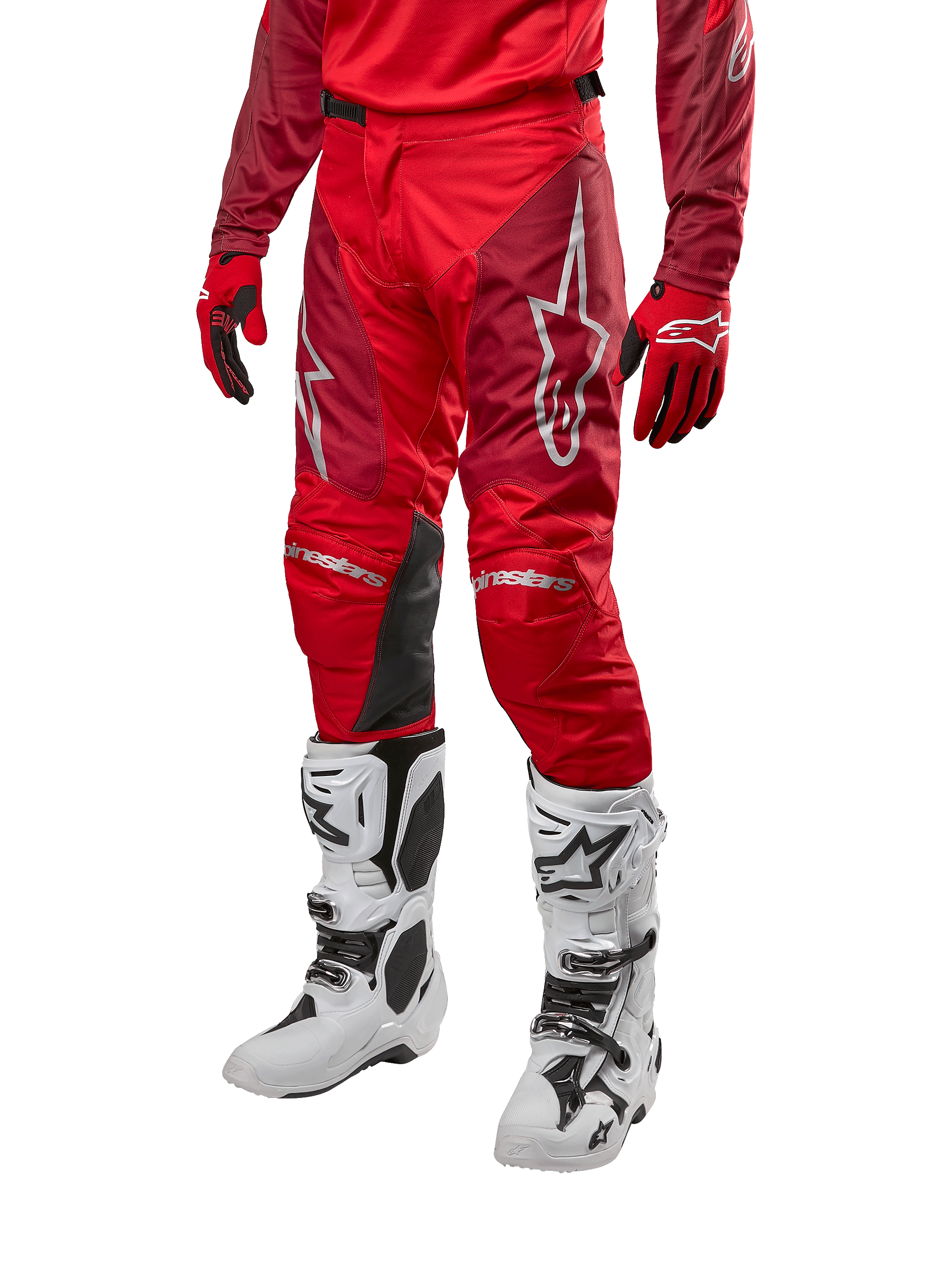 Alpinestars 2024 Racer Hoen Pants, spodnie motocrossowe, w kolorze Mars Red i bordowym, zestawione z pasującą czerwoną koszulką, rękawicami i białymi butami, wyposażone w czarne skórzane panele na kolanach i białe logo, wytrzymały sprzęt techniczny do wyścigów terenowych
