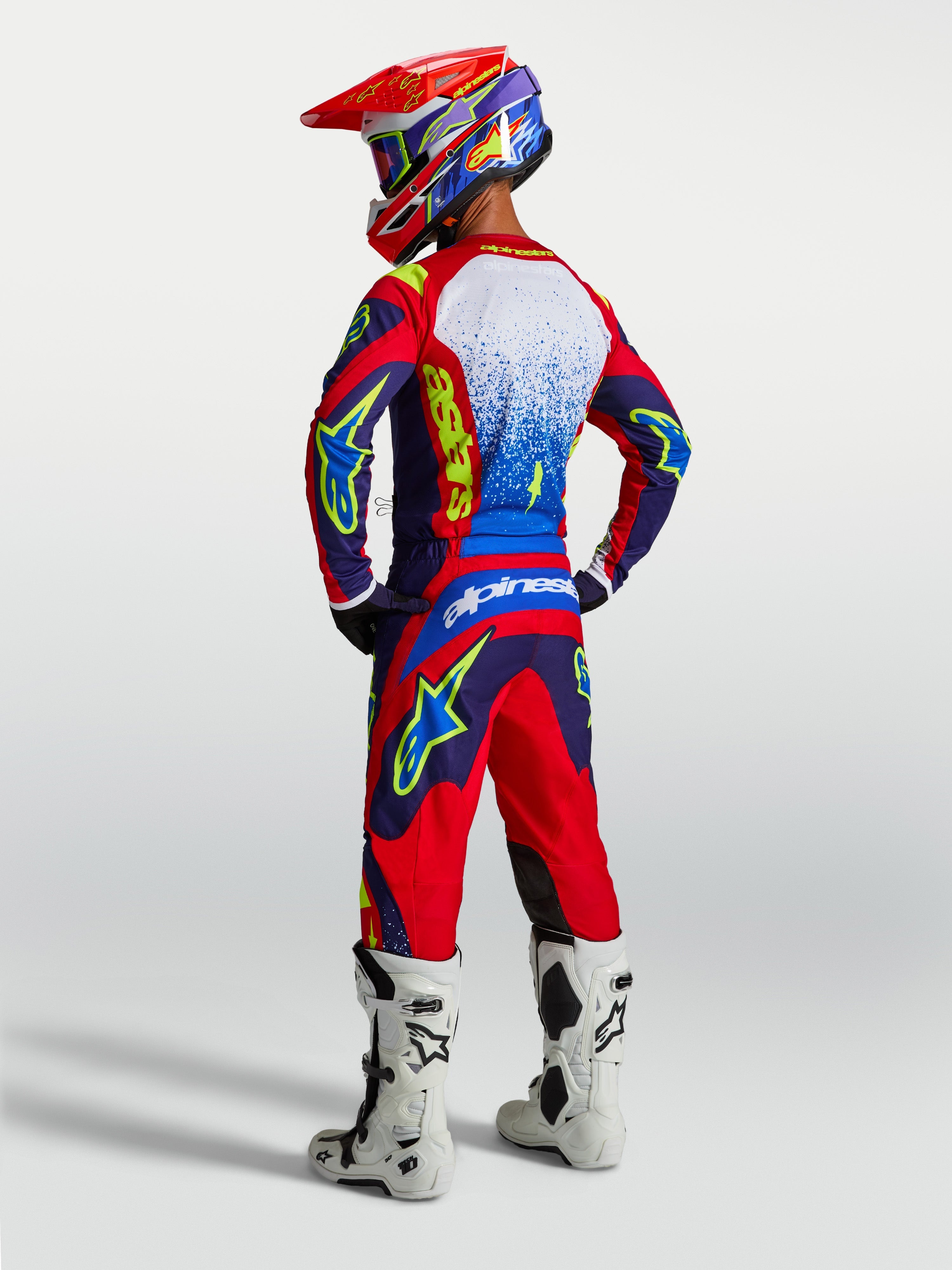 Alpinestars spodnie Fluid Drag i zestaw 2027 Fluid Drag Gear Set, niebiesko-czerwony strój motocrossowy, białe buty, tył.