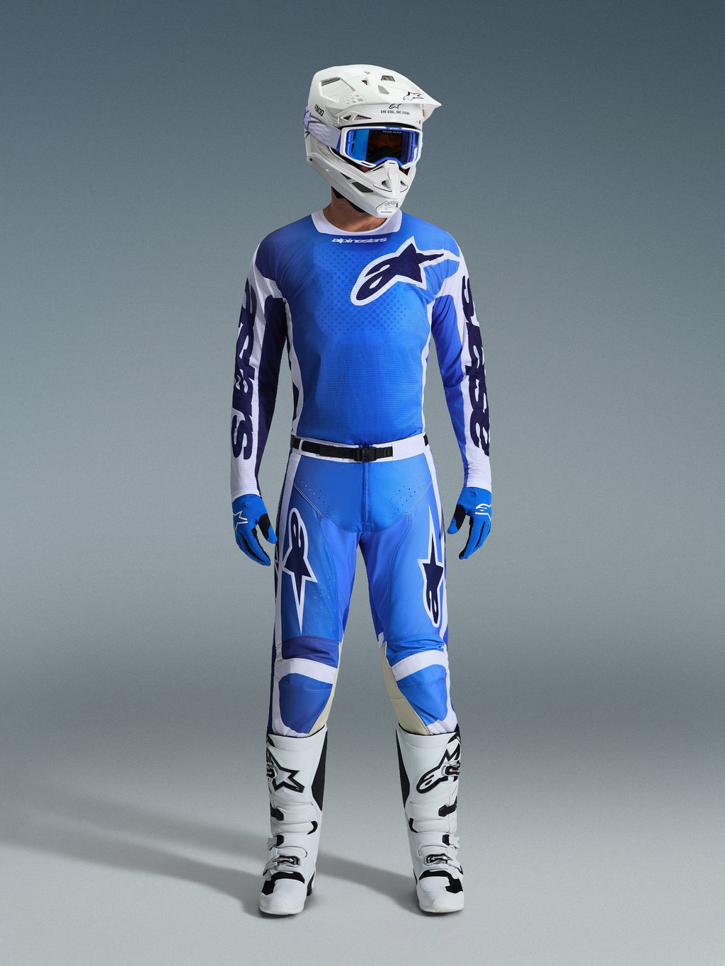 Alpinestars 2026 Racer Air Portl Pants, spodnie motocrossowe, kolor niebieski UCLA i biały, noszone jako część kompletnego zestawu wyścigowego z pasującą koszulką, białym kaskiem, niebieskimi goglami i białymi butami, z panelami o wysokim przepływie powietrza i wyrazistym brandingiem dla wydajności w terenie.