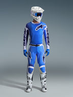 Alpinestars 2026 Racer Air Portl Pants, spodnie motocrossowe, kolor niebieski UCLA i biały, noszone jako część kompletnego zestawu wyścigowego z pasującą koszulką, białym kaskiem, niebieskimi goglami i białymi butami, z panelami o wysokim przepływie powietrza i wyrazistym brandingiem dla wydajności w terenie.