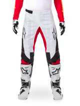 Alpinestars Limited Edition Techstar Deep Pants, spodnie motocrossowe, czarno-białe i intensywnie czerwone, zestawione z pasującą czerwoną bluzą, biało-czarnymi rękawicami i butami, białe przednie panele, czerwone akcenty po wewnętrznej stronie nogawek, czarne panele boczne, logo Alpinestars na udach, laserowo wycinane detale zapewniające wentylację