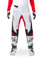 Alpinestars Limited Edition Techstar Deep Pants, Motocross Pants, White with Black and Red accents, featuring star logo and laser perforations, worn with white motocross boots and gloves, durable technical material for off-road riding