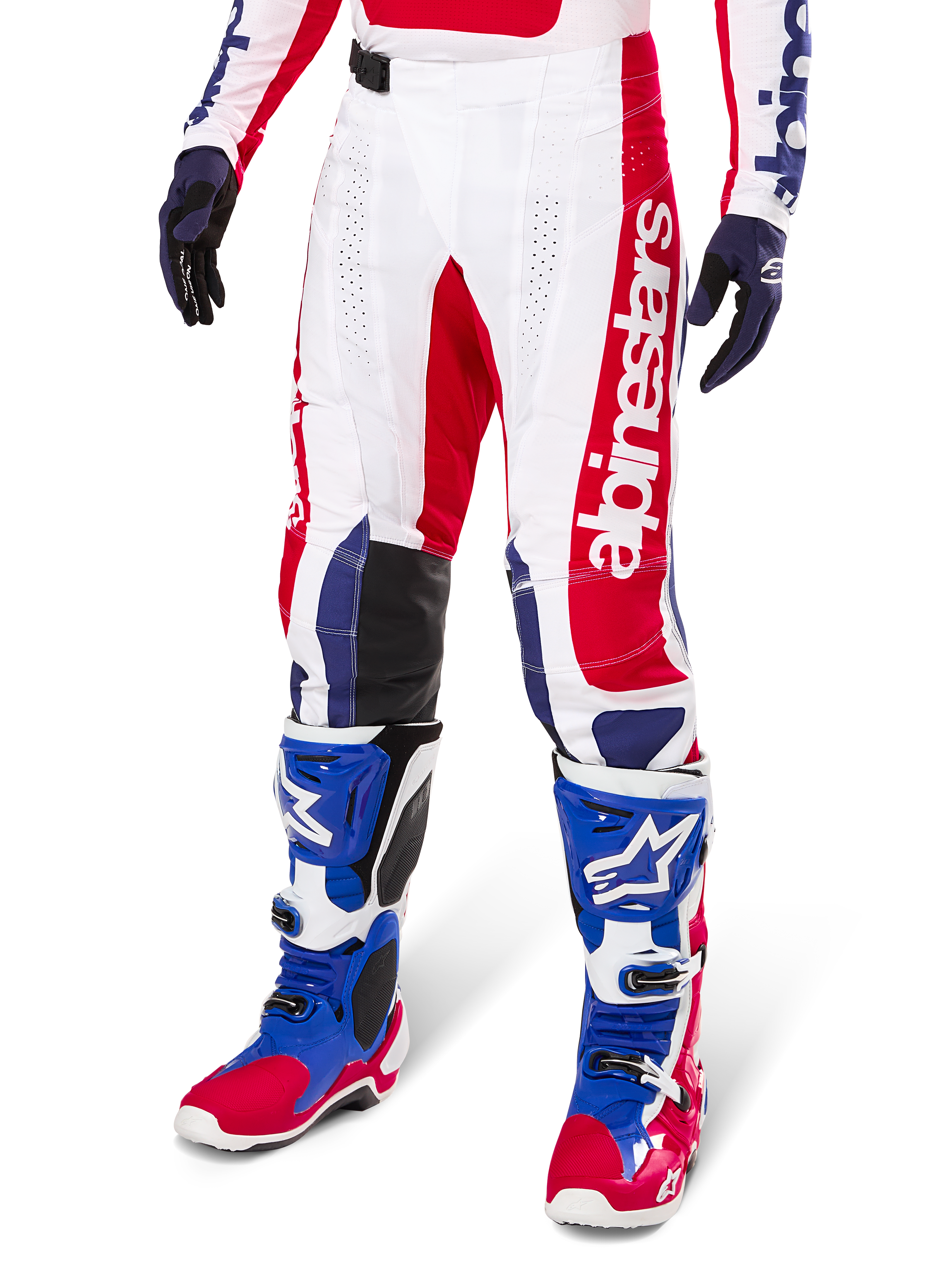 Alpinestars Limited Edition Techstar Fortitude Motocross Pants, spodnie motocrossowe, czerwono-biało-niebieska kolorystyka, noszone z dopasowanymi butami i rękawicami, pionowy branding Alpinestars, sportowy krój do wyścigów off-road
