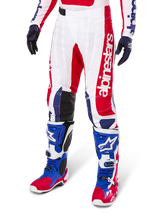 Alpinestars Limited Edition Techstar Fortitude Pants, Motocross Pants, Bright Red White and Blue, worn with matching off-road boots and gloves, featuring vertical branding on the leg, breathable perforated panels, and black reinforced knee sections, athletic race fit design