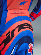 Alpinestars 2026 Supertech Vista Pants, spodnie motocrossowe, granatowe, koralowe i kobaltowe, zbliżenie na tył pokazujące wyraźny branding, laserowo wycinane perforacje dla wentylacji oraz logo „SUPERTECH” na pasku, elastyczny materiał techniczny do wyścigów terenowych