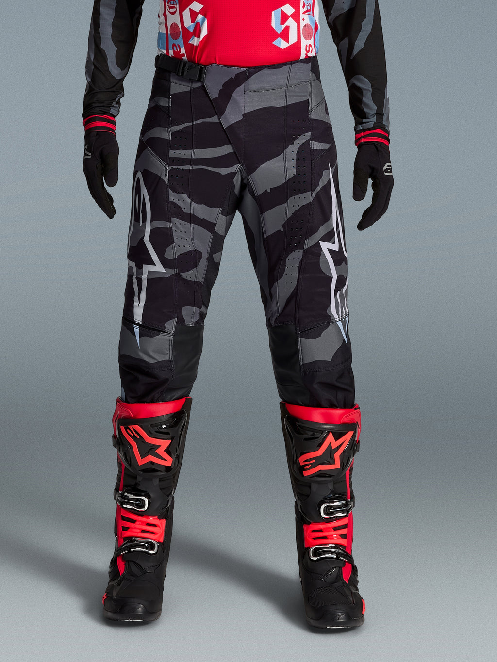 Alpinestars Spodnie Techstar Beast Coast Edycja Limitowana, czarne i pomarańczowe spodnie motocrossowe, wzór camo.