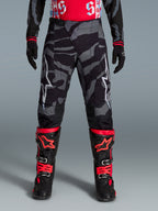 Alpinestars Spodnie Techstar Beast Coast Edycja Limitowana, czarne i pomarańczowe spodnie motocrossowe, wzór camo.