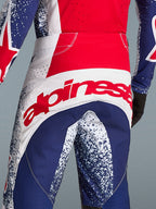 Alpinestars zestaw Techstar Unity edycja limitowana, czerwono-niebieskie spodnie motocrossowe z wyrazistym logo na tyle.