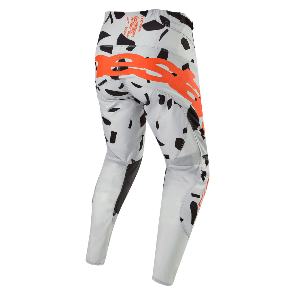 Alpinestars Techstar Rantera Pants 2024, spodnie motocrossowe, kolor Haze Gray Camo, widok z tyłu z dużym pomarańczowym logo na siedzeniu, czarne wzory graficzne na szarym materiale, sportowy design do jazdy w terenie