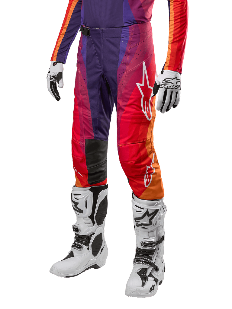 Alpinestars Techstar Pneuma Pants 2024, spodnie motocrossowe, fioletowe z pomarańczowymi, czerwonymi i niebieskimi akcentami, białe logo gwiazdy, białe buty i rękawice motocrossowe, sportowy krój