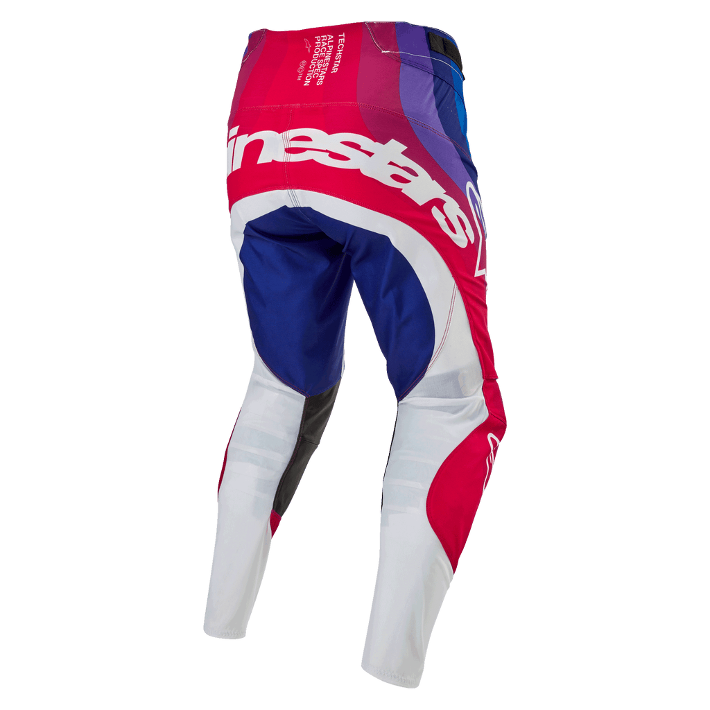 Alpinestars Techstar Pneuma Pants 2024, spodnie motocrossowe, niebieskie, czerwone i białe, widok z tyłu z dużym białym brandingiem Alpinestars na siedzeniu, niebieskie i czerwone panele z białymi dolnymi częściami nogawek, wytrzymała konstrukcja do zawodów off-road