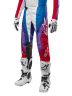 Spodnie Alpinestars Techstar Pneuma 2024, spodnie motocrossowe, Blue Mars Red White, noszone z dopasowaną koszulką, białymi butami wyścigowymi i rękawicami, dynamiczny wzór graficzny z czerwonymi, niebieskimi i fioletowymi akcentami, perforowane dla oddychalności