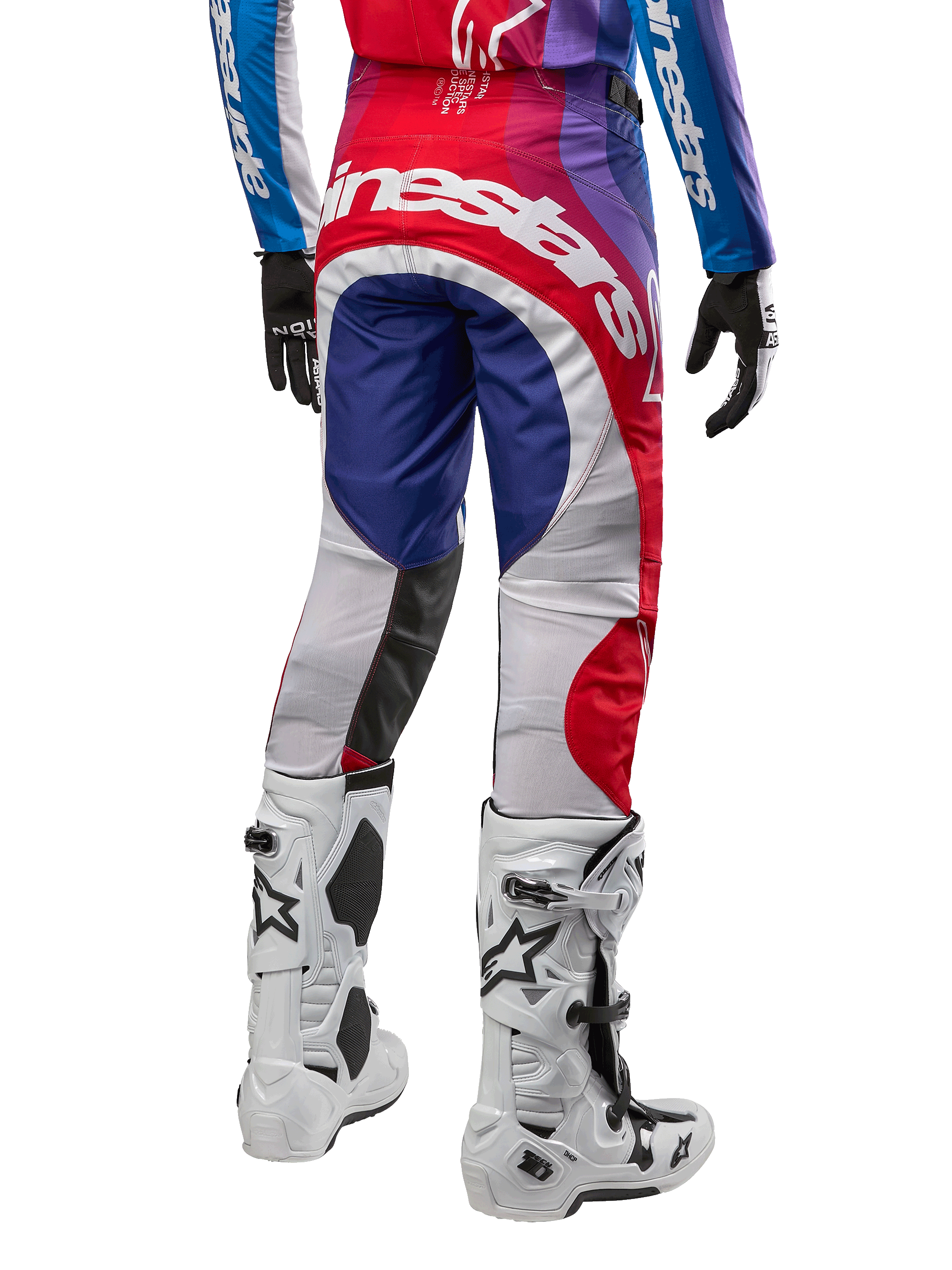 Spodnie Alpinestars Techstar Pneuma 2024, spodnie motocrossowe, kolor Blu Mars Red White, widok z tyłu w zestawie z pasującą koszulką i białymi butami, wyraziste białe logo na siedzeniu i wielokolorowe panele, profesjonalna odzież motocrossowa