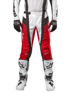 Alpinestars 2024 Techstar Ocuri Pants, spodnie motocrossowe, czerwono-biało-czarne, widok z przodu w zestawie z dopasowaną białą bluzą, czarnymi rękawicami i białymi butami, posiadają oddychające perforowane panele i wyścigowy krój dla wydajności off-road.