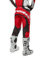 Alpinestars 2024 Techstar Ocuri Pants, spodnie motocrossowe, kolor Mars Red White and Black, widok z tyłu z dużym białym logo Alpinestars na siedzeniu, czarne siatkowe panele wentylacyjne, noszone z biało-czarnymi butami motocrossowymi, sportowy krój race-fit do jazdy terenowej