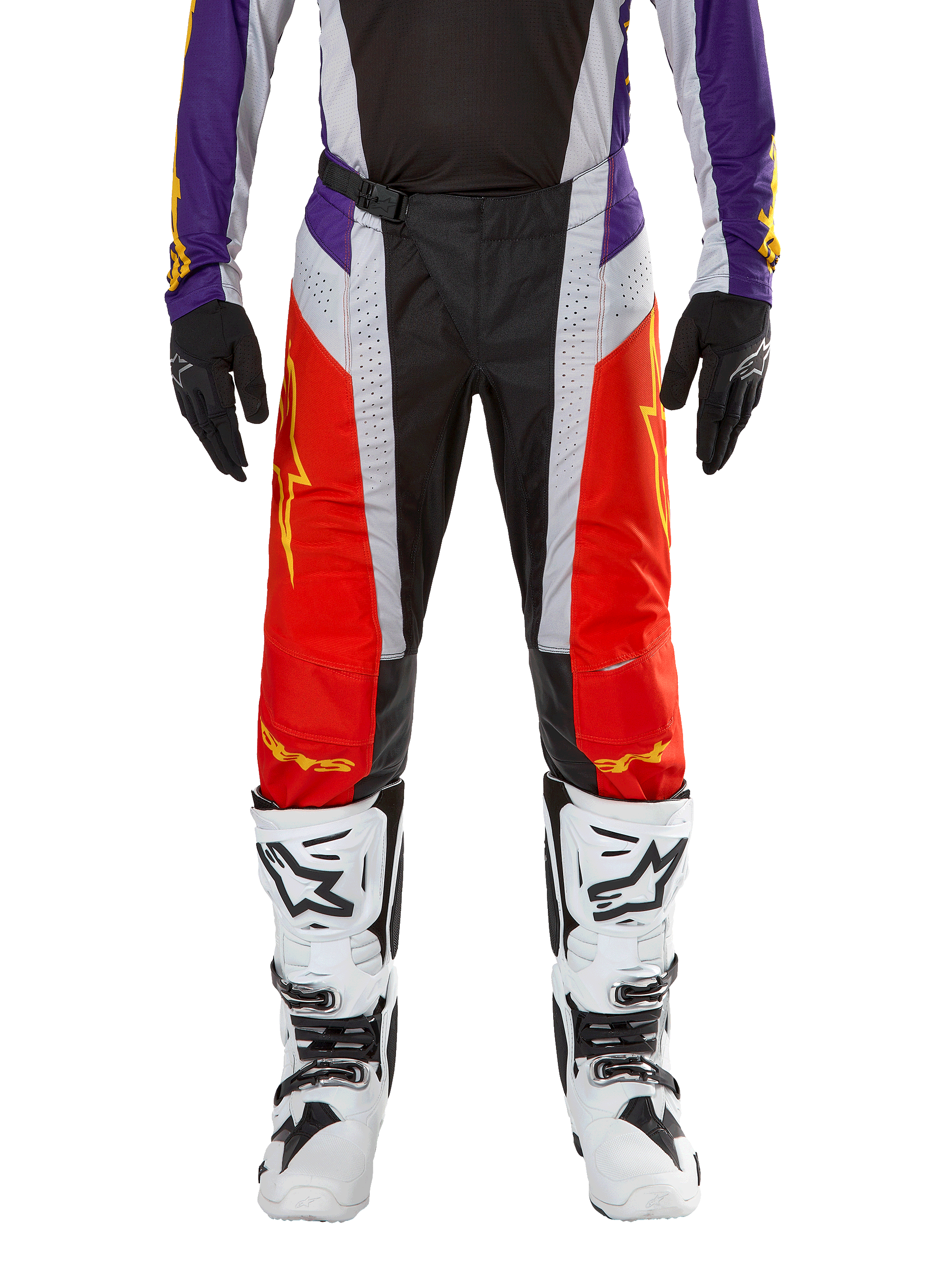 Spodnie Alpinestars Techstar Ocuri 2024, spodnie motocrossowe, jaskrawopomarańczowe, fioletowe i czarne, noszone z pasującą koszulką, czarnymi rękawicami i białymi butami, posiadają jaskrawopomarańczowe panele przednie, fioletowe akcenty w pasie i perforowane szare sekcje, techniczny design do wyścigów off-road