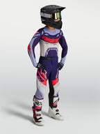 Alpinestars Youth Supertech Dyna, młodzieżowe spodnie motocrossowe, fioletowo-różowe fluo, elastyczny rip-stop, na zawodniku.