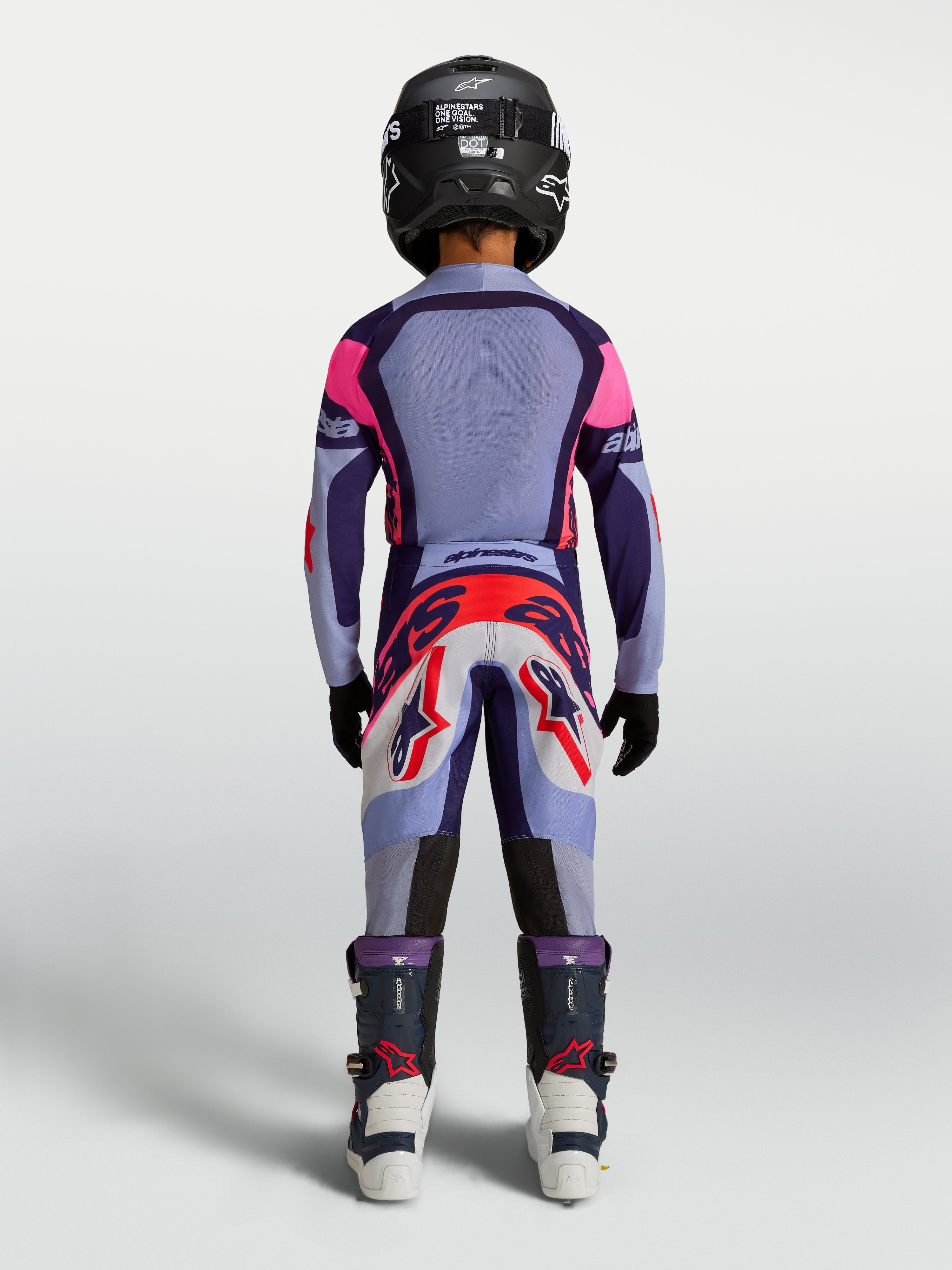 Alpinestars spodnie Supertech Dyna młodzieżowe, fioletowe i jasnofioletowe spodnie motocrossowe, widok z tyłu na zawodniku.