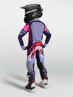 Alpinestars Supertech Dyna, młodzieżowe spodnie motocrossowe, fioletowe i różowe fluo, widok z tyłu na zawodnika