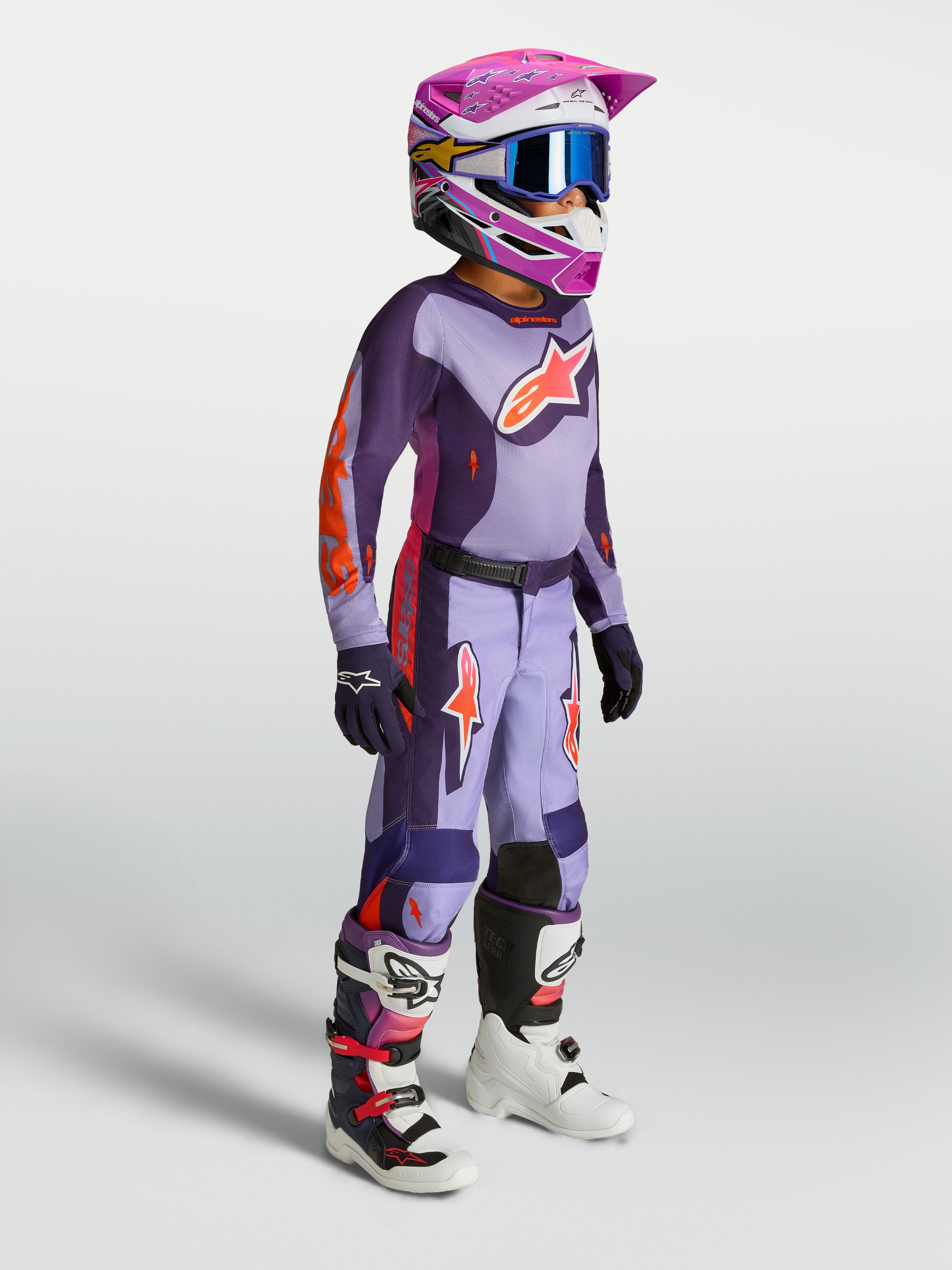 Alpinestars Spodnie Fluid Hunt Młodzieżowe, fioletowo-różowy zestaw motocrossowy dla młodych jeźdźców z kaskiem i butami.