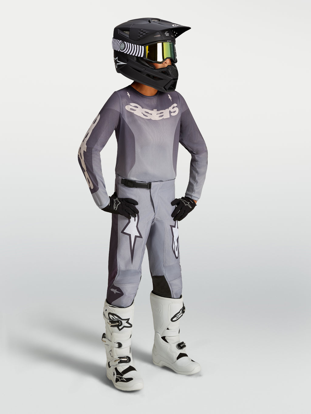 Alpinestars Youth Fluid Amber, młodzieżowe spodnie motocrossowe, piaskowe i białe, sportowy krój z grafiką gwiazdy.