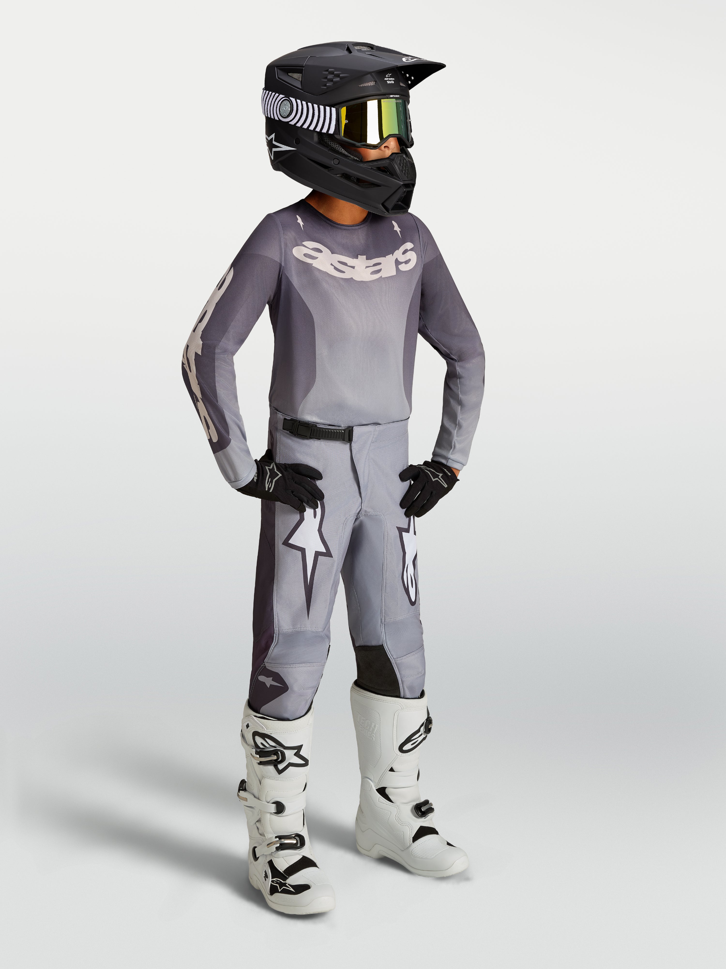 Alpinestars Youth Fluid Amber, młodzieżowe spodnie motocrossowe, piaskowe i białe, sportowy krój z grafiką gwiazdy.