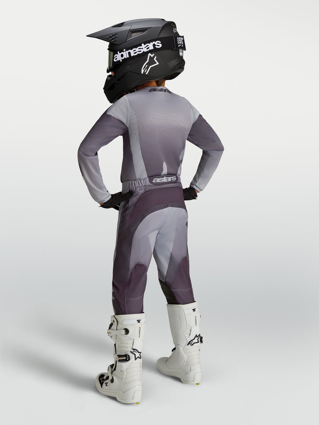 Spodnie Alpinestars Youth Fluid Amber, młodzieżowe spodnie motocrossowe, szare i fioletowe, sportowy krój, białe buty.