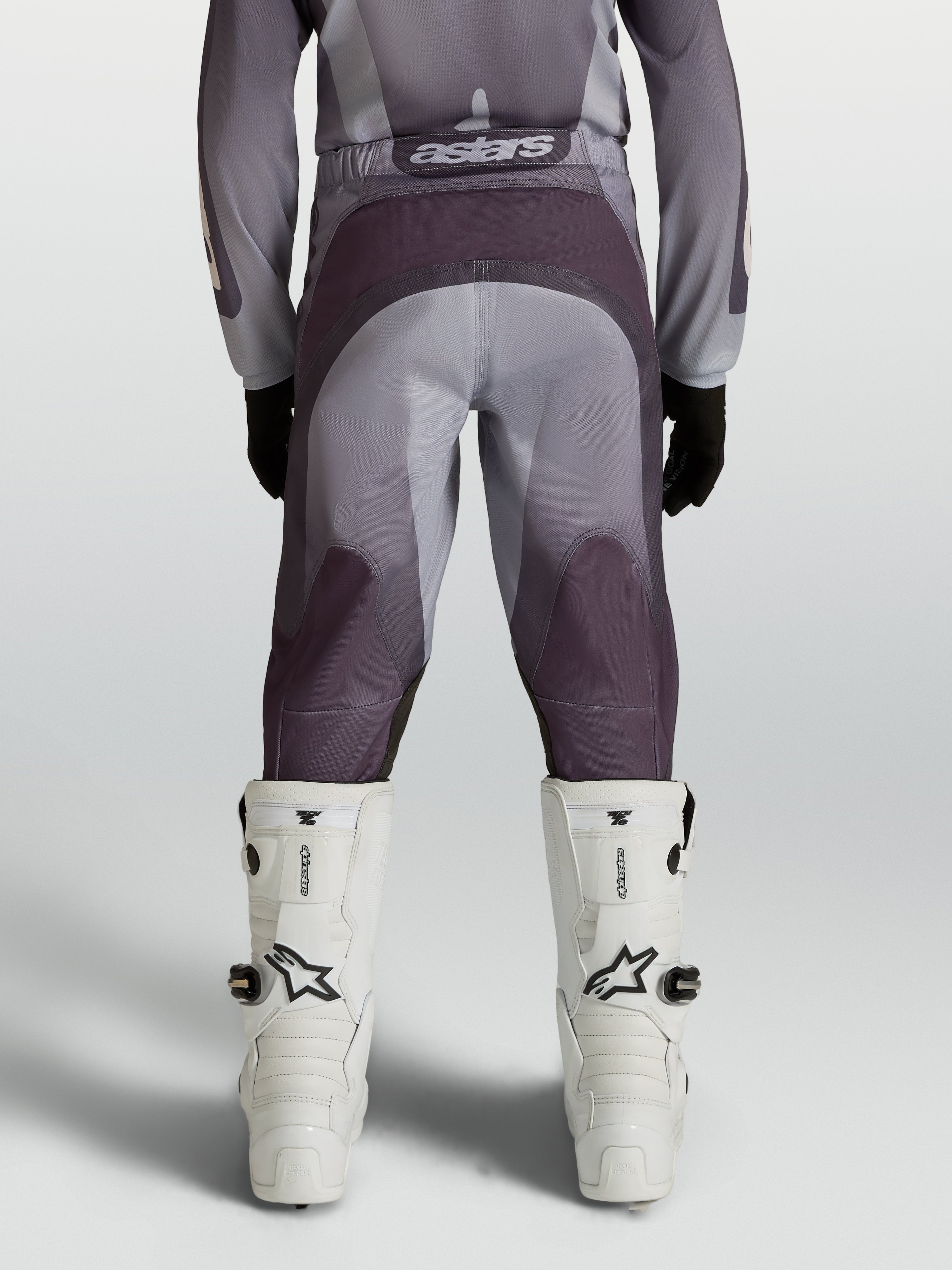 Alpinestars Spodnie Fluid Amber Młodzieżowe, spodnie motocrossowe off-road, szare i beżowe, wzmocnione siedzenie i elastyczne panele, widok z tyłu.